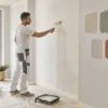 Imbianchino applica una pittura per interni in un soggiorno
