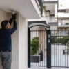 Installatore regola una telecamera all’ingresso di un condominio