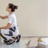 Proprietaria tinteggia una parete durante lavori in economia