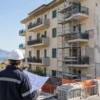 Tecnico davanti a un condominio in riparazione dopo eventi sismici