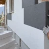Pannelli EPS bianchi e grafitati con operaio che allinea una lastra in facciata
